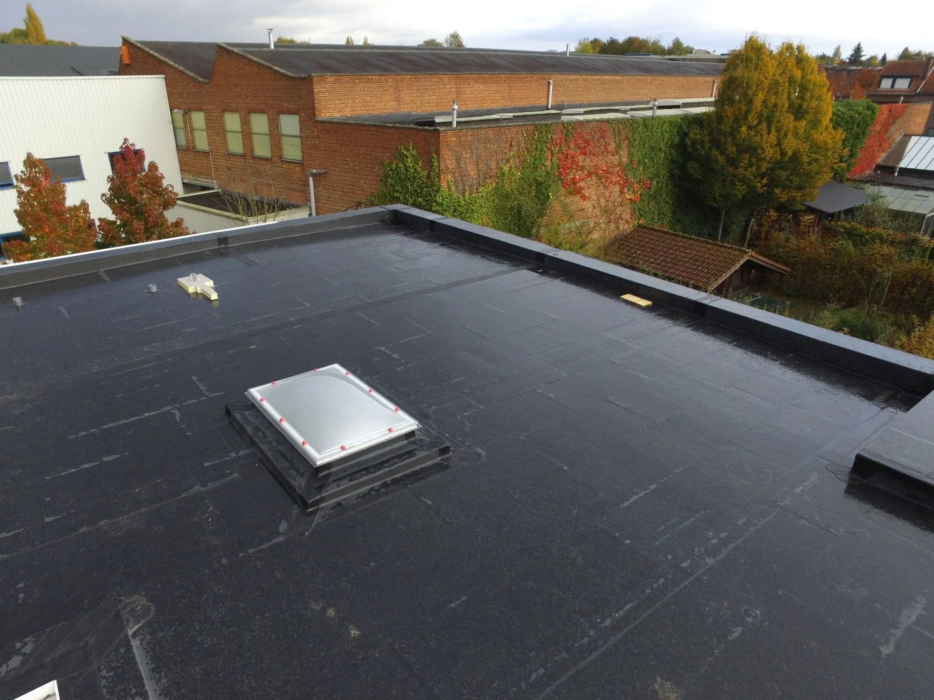 flat roof roofers inspecting a commercial rubber roof