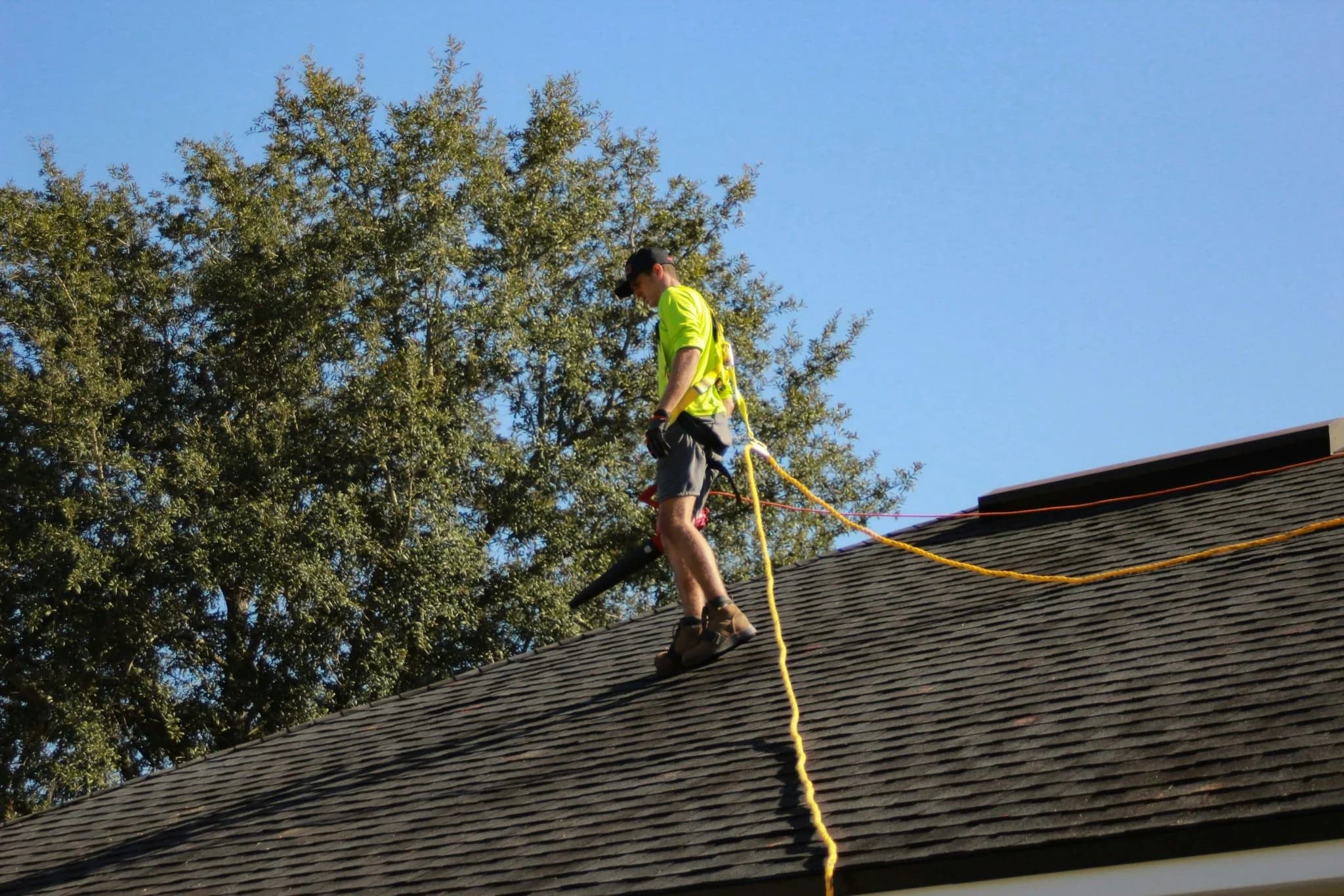 A man on a roof working with a rope