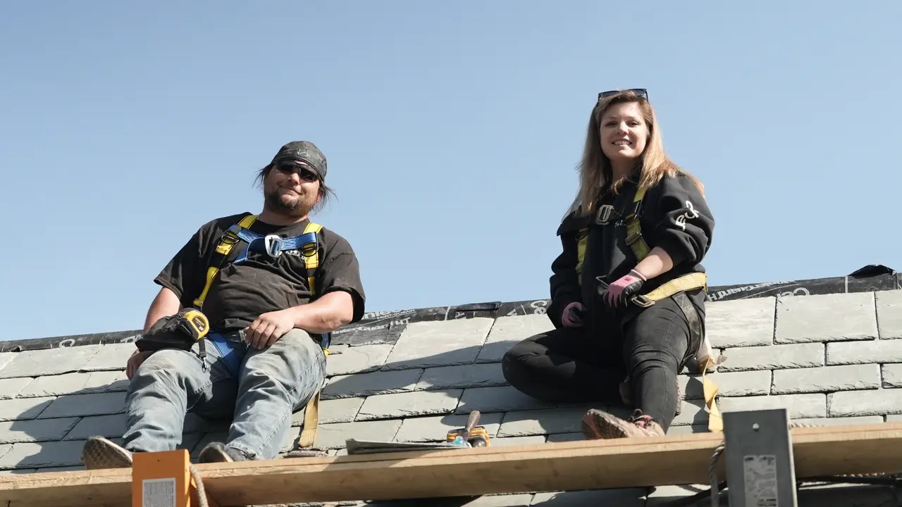 Two Crown roofers on a slate roof during a historic restoration.