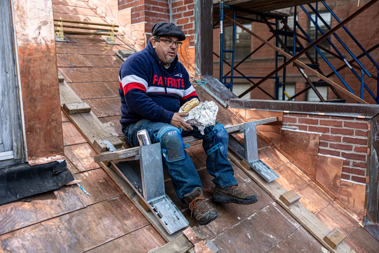 Roofer taking a break on a newly laid copper roof.