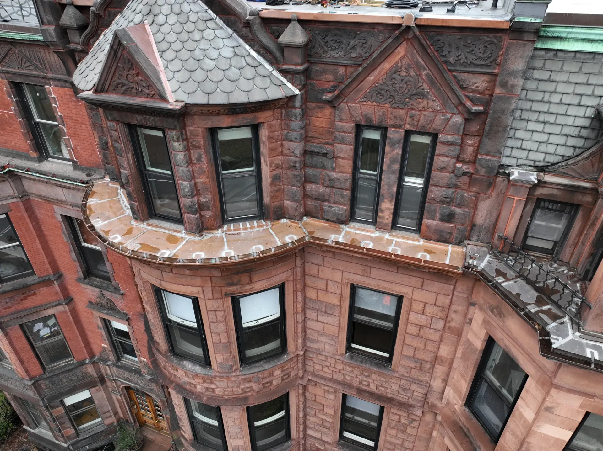 Historic Boston brownstone facade with carved stone, brick, and restored masonry details.