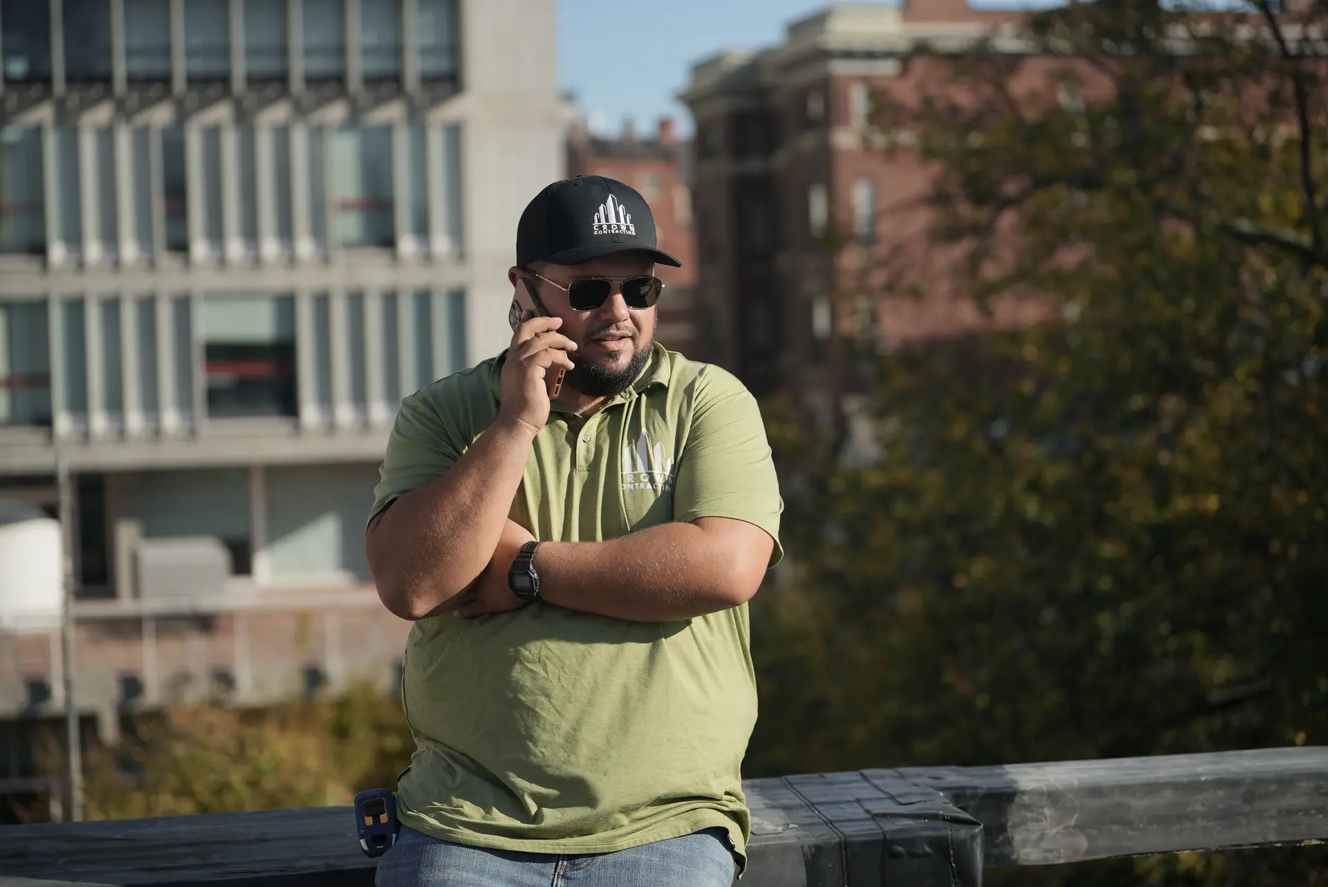 A Crown Contracting project lead on a Boston rooftop, on the phone with a client.